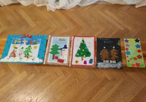 Prezentacja prac konkursowych dzieci rozłożonych na ławce.