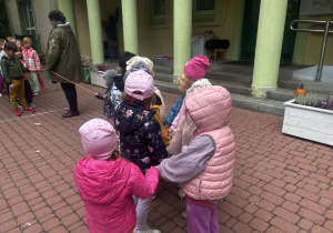Dzieci podzielone na dwa zespoły, przygotowują się do przeciągania liny.