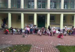 Dzieci ustawione w rzędzie próbują przejść pod liną nie dotykając jej.