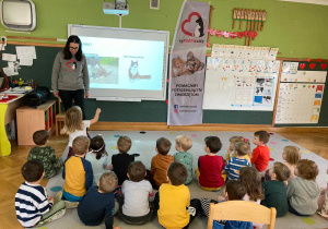 Pani z fundacji tłumaczy dzieciom o potrzebie pomagania zwierzętom.