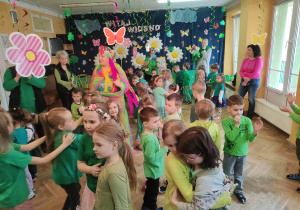 Dzieci ubrane na zielono tańczą do muzyki podczas balu z okazji powitania Wiosny.