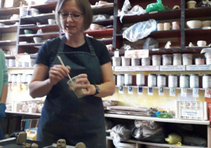 Prowadząca warsztaty ceramiczne wyjaśnia, co dzieci będą miały do zrobienia z gliny.