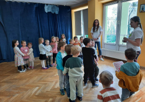 Dzieci stoją ustawione w pary, trzymając się za ręce, są bankiem, w środku stoi jedno dziecko, jest pieniędzmi. Banki dobrze chronią pieniądze, więc jak są w banku są bezpieczne.