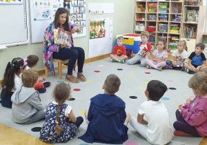 Grupa dzieci słucha czytanego utworu w ramach akcji ,,Czytamy, głowy otwieramy".