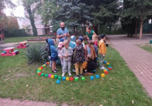 Dzieci stoją w wybudowanym przez siebie okręgu z klocków.