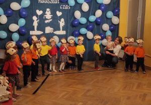 Dzieci ustawione w półkolu prezentują ruchem i śpiewem przygotowane piosenki.