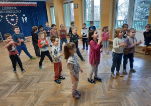 Dzieci stoją naprzeciwko prowadzącej i starają się powtarzać nowy układ taneczny.