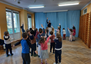 Przedszkolaki wraz z prowadzącą tańczą do piosenki "Baby shark".