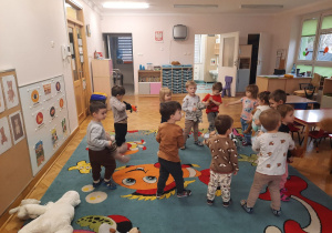 Dzieci ustawione w kółeczku tańczą ze swoimi pluszakami.