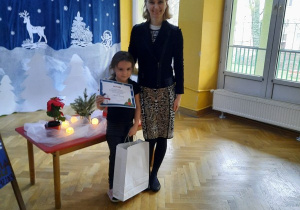 Dziewczynka odbiera dyplom oraz nagrodę za zajęcie I miejsca w konkursie, w kategorii wiekowej 5-6 latków.