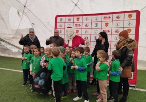 Przedszkolaki wraz z opiekunami, przedstawicielami władz oraz Mikołajem pozują do pamiątkowego zdjęcia z Mikołajkowego Festiwalu Sportu.