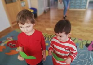 Dwóch chłopców ma serduszka w identycznym kolorze i stoją obok siebie trzymając je w ręku.