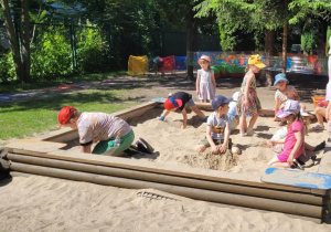Dzieci szukają skarbów zakopanych w piasku.