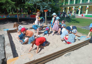 Dzieci szukają skarbów zakopanych w piasku.