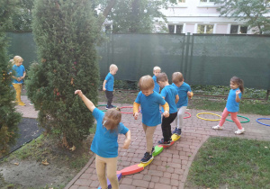 Dziewczynka i trzech chłopców przechodzą stopa za stopą po torze.