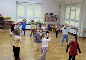 Przedszkolaki powtarzają układ za Panią prowadzącą zajęcia.