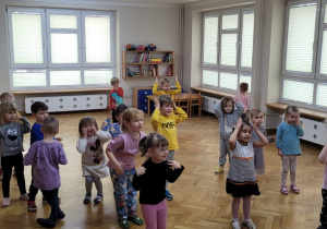 Maluszki wskazują na sobie wymienione w piosence części ciała.