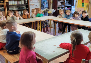 Dzieci siedzą przy stolikach ustawionych w kole w Pracowni Ceramicznej "Amfora".