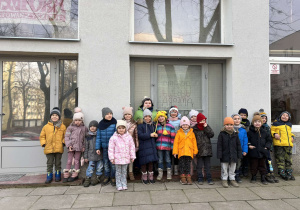 Dzieci stoją przed wejściem do Pracowni Ceramicznej "Amfora" i pozują do zdjęcia grupowego.