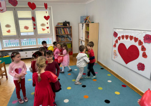Dzieci tańczą w parach z balonami między sobą.