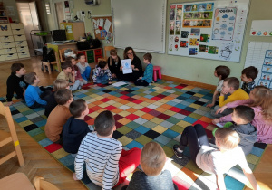 Bohater Tygodnia: chłopiec z pomocą mamy prezentuje grupie książeczkę o sobie.