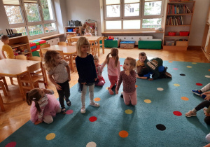 Dziewczynka mimiką twarzy prezentuje wybraną przez siebie emocję - radość.