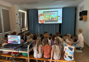 Dzieci oglądają filmik edukacyjny pt. "Karolek przedstawia Dzień Kropki".