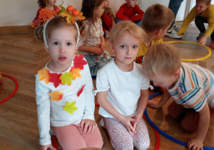 Dwie dziewczynki siedzą wewnątrz koła hula-hop.