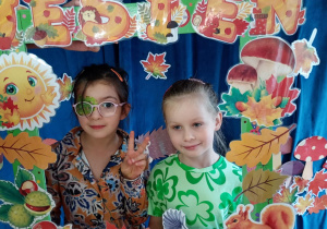 Dwie dziewczynki pozują wewnątrz jesiennej fotobudki.