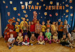 Starszaki pozują na tle dekoracji jesiennej wraz z Panią Jesienią.