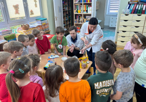 Mama chłopca prezentuje dzieciom częściowo przygotowaną "maść leczniczą" w ramach projektu Bohater Tygodnia.