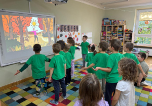 Dzieci stoją z rękoma rozłożonymi na boki.