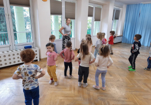 Maluchy stoją w rozsypce z rękoma na bioderkach.