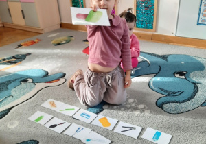 Dziewczynka pokazuje wybraną przez siebie ilustrację - mydło w kostce.