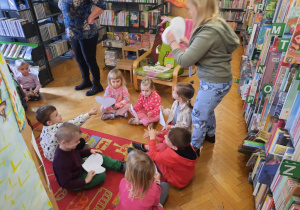 Bibliotekarka rozdaje grupie dzieci serca.