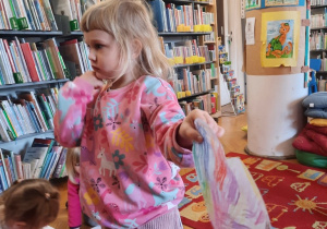 Dziewczynka stoi, a w ręku trzyma pięknie wykolorowane serduszko.