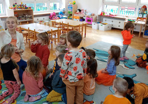 Nauczycielka objaśnia dzieciom budowę dyni na podstawie ilustracji.