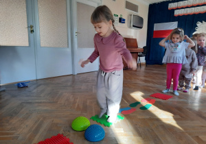 Dziewczynka przechodzi przez sensoryczny tor przeszkód.