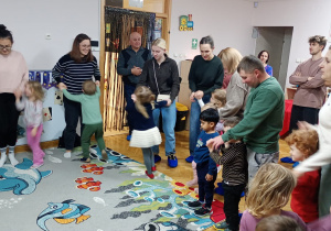 Rodzice tańczą ze swoimi dziećmi.