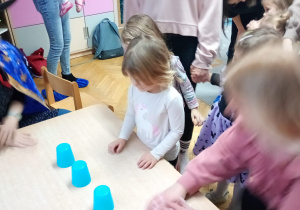 Dziewczynka zastanawia się, który kubeczek wybrać.