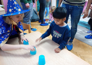 Chłopiec sięga po wybrany przez siebie kubeczek.