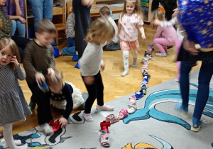 Dzieci przestawiają swoje buciki na początek rzędu.