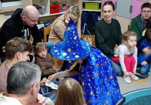 Dziewczynka losuje kartonik z zawodem z magicznego woreczka.