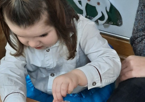 Dziewczynka ozdabia za pomocą farb szklany lampion.