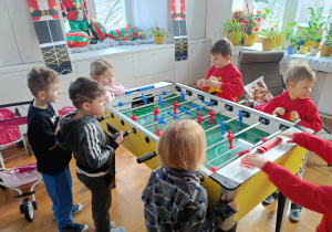 Chłopcy grają w piłkarzyki podczas wizyty na świetlicy szkolnej.