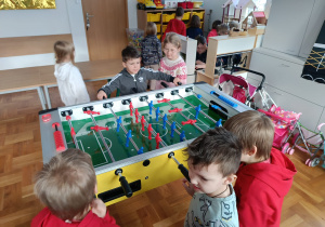 Chłopcy grają w piłkarzyki podczas wizyty na świetlicy szkolnej.