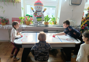 Chłopiec gra z dziewczynką w cymbergaja na świetlicy szkolnej.