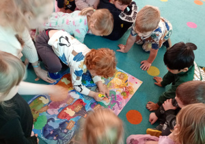 Chłopiec przykleja postać bohatera na plakacie Czuciaków.