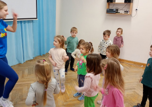 Przedszkolaki obserwują i starają się powtarzać ruchy wykonywane przez prowadzącą.