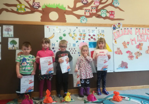 Laureaci konkursu plastycznego pt. "Jesienny krasnal". Dzieci stoją i prezentują w rękach dyplom i nagrody za udział w konkursie.